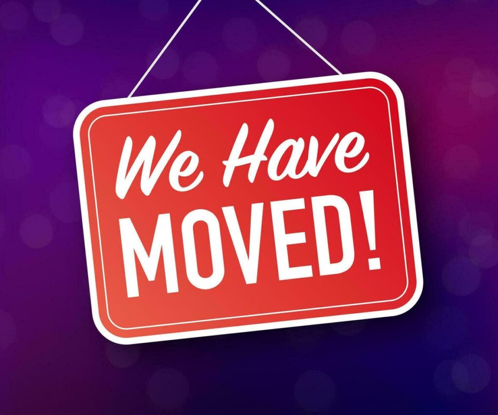 Announcement sign: red, rounded rectangle reads "We Have Moved!" on a purple background.
